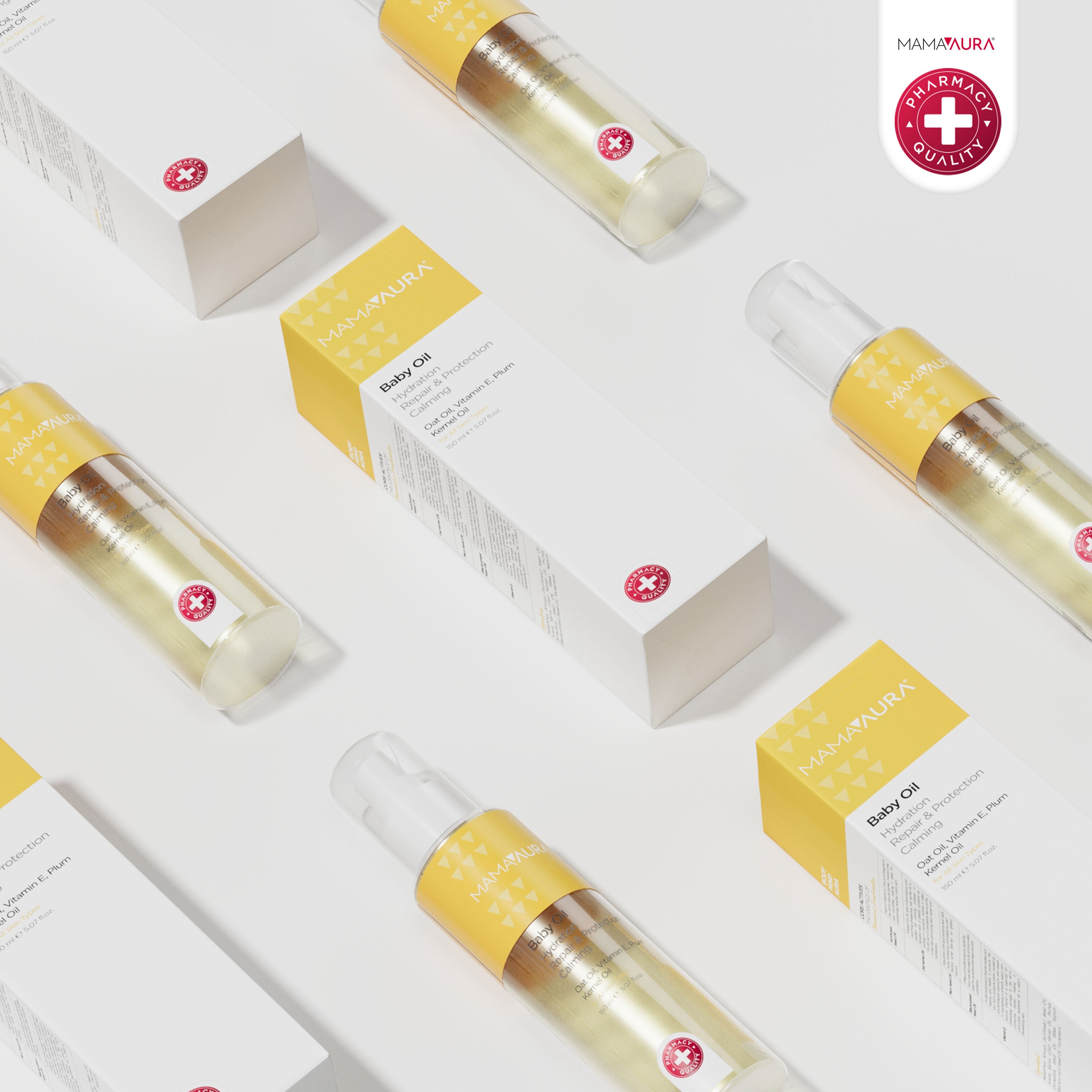 Baby Oil şişeleri ve sarı ambalajlı kutuları açık zeminde kuşbakışı çoklu düzenlemede, hassas bebek cildi için Yulaf Yağı ve Erik Çekirdeği Yağı içerikli besleyici bebek yağı serisi
